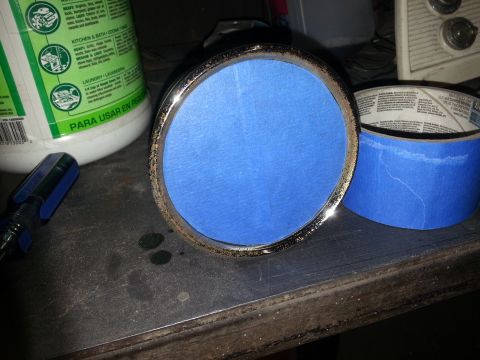 1967 Ford F-100 - Headlight assembly covered with blue tape, on a workbench with tools and cleaning supplies.