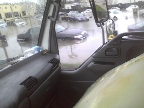 2003 Ford Crown Victoria - Cars are submerged in floodwaters on a street, as seen from the interior of a truck.