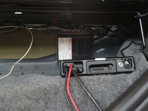 1991 Ford LTD Crown Victoria - Close-up of wiring and electronic components installed in the trunk of a vehicle.