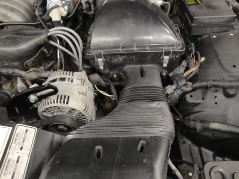 1991 Ford LTD Crown Victoria - Close-up view of a vehicle's engine bay, highlighting the alternator and air intake system. A label with text is visible in the lower left…