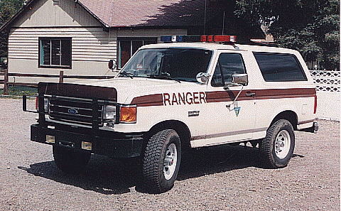 1994 Ford Bronco - This Ford Bronco, likely from the early 1990s, is marked as a Ranger vehicle with distinctive striping and emergency lights.