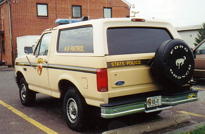 Tan 1994 Ford Bronco with K-9 Patrol and State Police markings, spare tire on rear