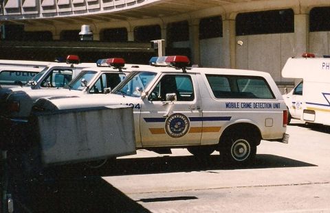 1994 Ford Bronco - Several white Ford Bronco police vehicles are parked in a row, one displaying "MOBILE CRIME DETECTION UNIT" on its side.