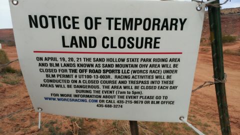 1994 Ford Bronco - A sign details a temporary land closure for an event at Sand Hollow State Park, providing dates, permit information, and contact numbers.