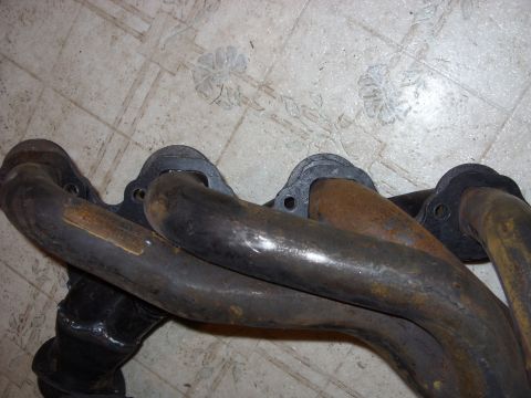 1967 Ford F-250 - Close-up view of an exhaust manifold, showing its pipes and mounting flanges.