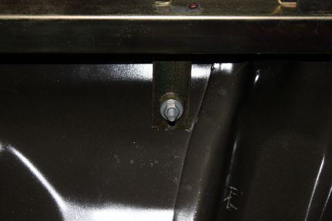 2007 Ford Crown Victoria - A close-up view of a mounting bracket and bolt assembly within a vehicle's interior.