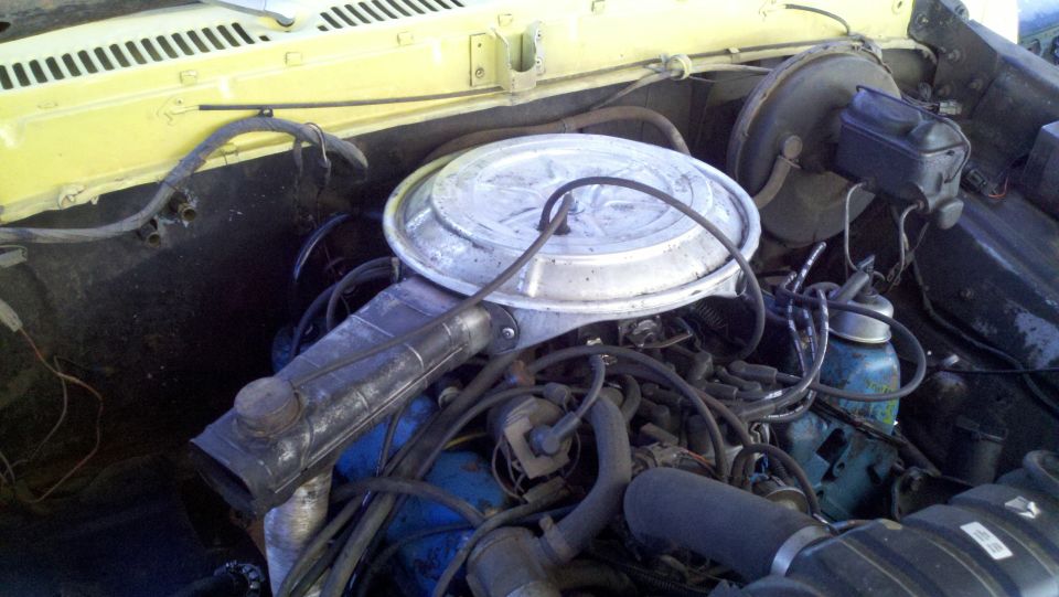 engine bay with air cleaner, brake booster, and various hoses and wires