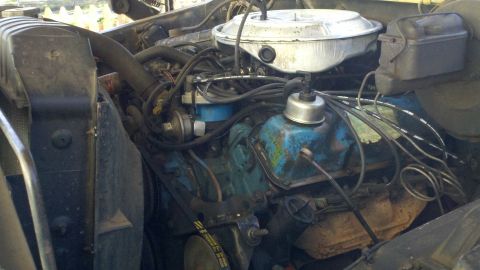 1978 Ford Bronco - The engine bay of a 1978 Ford Bronco is visible, the V8 engine with blue valve covers and a chrome air cleaner.