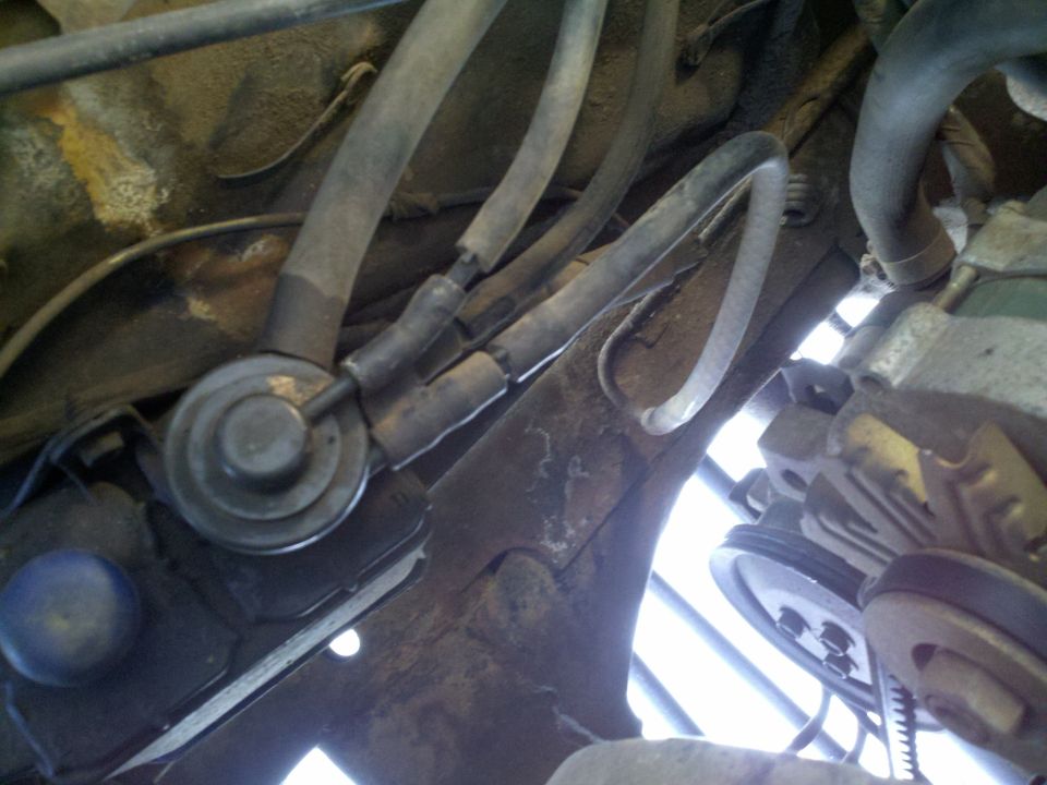 Engine vacuum hoses and a valve connected to rusty metal framework