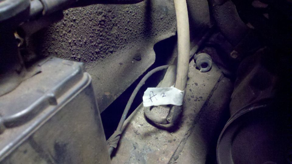 Close-up of engine bay with tape labeled "A 2" on a wire bundle