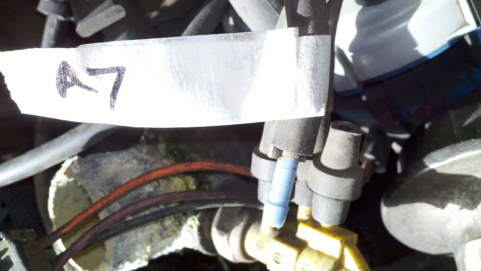 Close-up of engine components with a white label marked "A7" taped to a hose