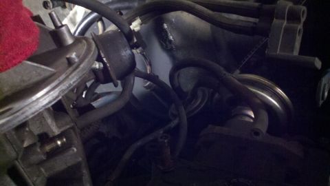 1978 Ford Bronco - This image shows a close-up view of various engine components, including hoses and a red cloth, within a vehicle.