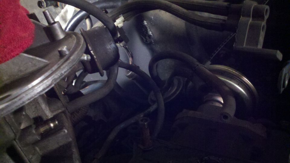 Close-up of engine parts with hoses and a red cloth