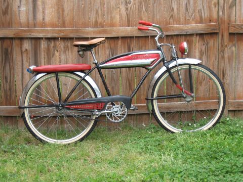 1994 Ford Bronco - A vintage bicycle with red accents and whitewall tires is parked in front of a wooden fence.