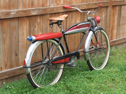 1994 Ford Bronco - A vintage J.C. Higgins bicycle, a red seat and fender light, is parked outdoors next to a wooden fence.
