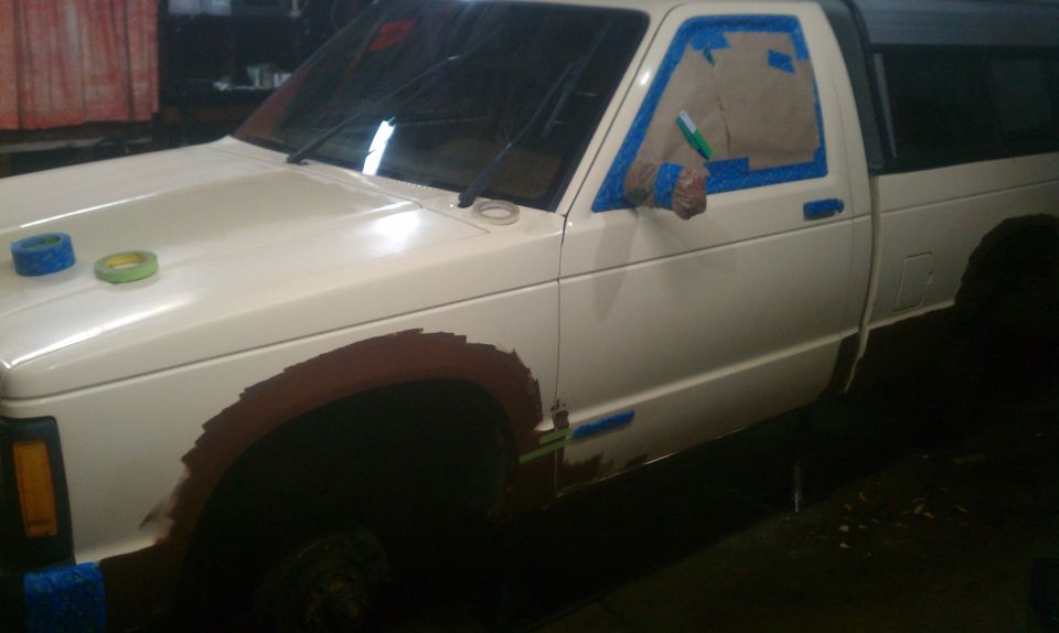 White 1991 Chevrolet S10 pickup truck being prepped for paint, driver's side