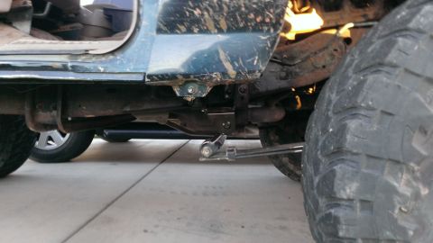 1994 Ford Bronco - The underside of a vehicle, its suspension components and a large, tire.