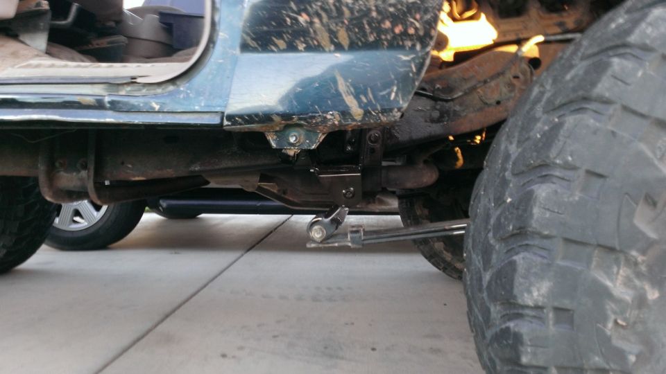 Close-up of a dirty off-road vehicle's side, showing the suspension and large tire