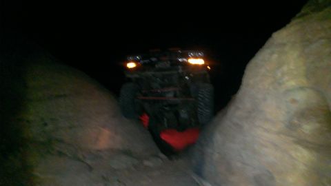 1994 Ford Bronco - Vehicle appears to be stuck in a narrow passage between rocks at night.