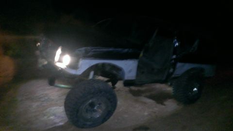 1994 Ford Bronco - A 1994 Ford Bronco is seen at night, equipped with large tires for off-road use.