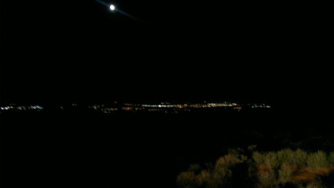 1994 Ford Bronco - A nighttime landscape the moon and a distant city skyline, with the Supermotors.net logo visible.