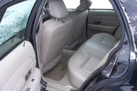 2007 Ford Crown Victoria - The interior of a car shows the back seat and door panels. The window is covered in frost.