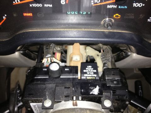 2005 Jeep Wrangler - Close-up view of dashboard gauges and a black LED flasher relay unit.