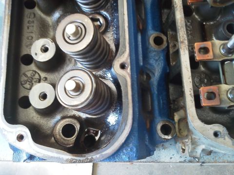 1988 Ford Bronco - Close-up view of an engine's cylinder head, revealing internal components like valve springs and bolts.