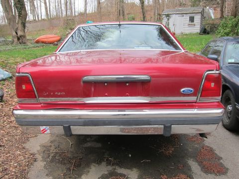 1991 Ford LTD Crown Victoria - Rear view of a red 1991 Ford Crown Victoria LTD, showing its distinctive taillights and chrome bumper.