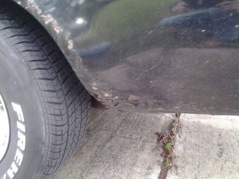 1975 Chevrolet Chevelle - This image shows the lower rear fender of a vehicle with visible rust damage and a tire.