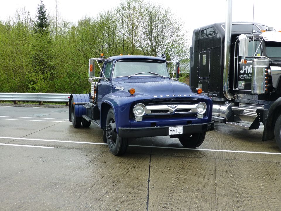Blue Mercury COE truck parked next to a black semi-truck. License plate reads 6307