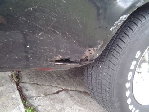 1975 Chevrolet Chevelle - The fender of a vehicle displays extensive rust and damage near the wheel well.