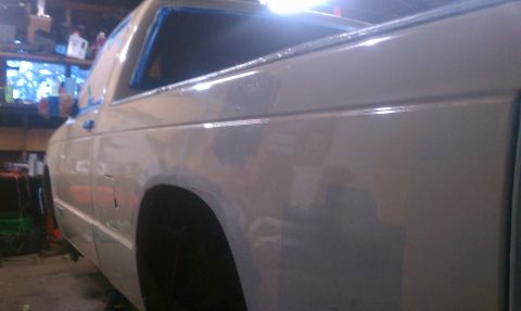 1991 Chevrolet S10 - A light-colored Chevrolet S10 pickup truck is shown from the side, with its windows taped off for painting or repair work.
