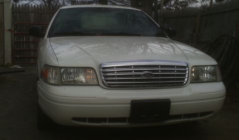 2006 Ford Crown Victoria - White 2006 Ford Crown Victoria shown from the front, a chrome grille and headlights.
