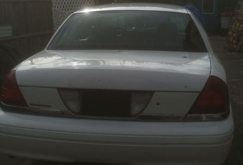 2006 Ford Crown Victoria - The rear of a white Ford Crown Victoria is shown with a chrome trim piece.