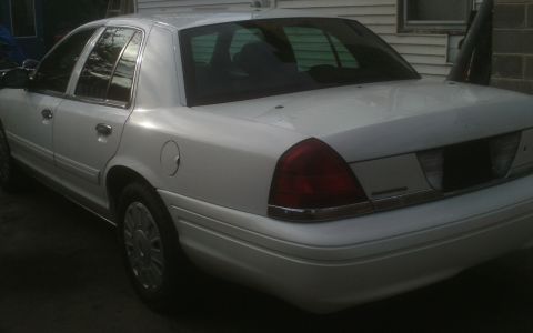 2006 Ford Crown Victoria - A white sedan is parked outdoors, viewed from the rear three-quarter angle.
