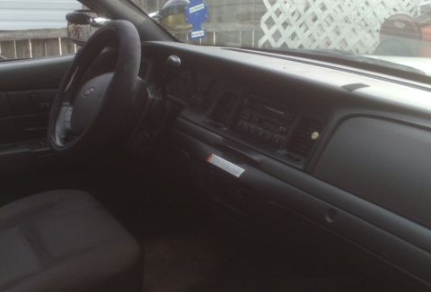 2006 Ford Crown Victoria - The interior of a 2006 Ford Crown Victoria, the dashboard, steering wheel, and passenger seat.