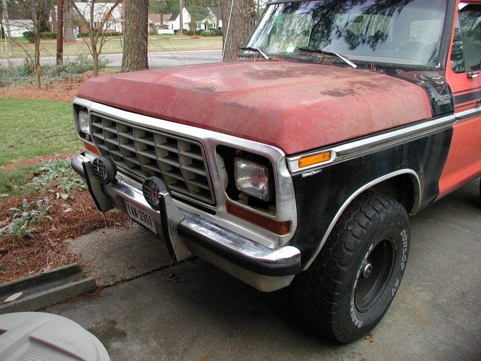 Front end of red and black Ford Bronco with square grille and round headlights