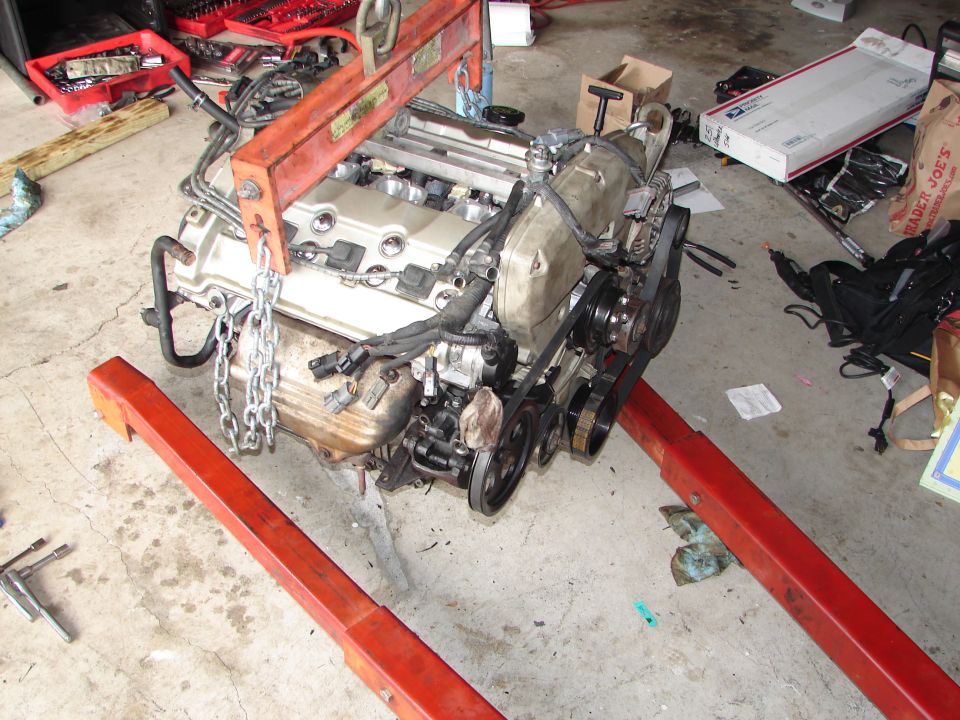 Engine on an engine hoist, with tools and boxes in the background