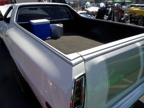 1973 Ford Ranchero - The bed of a white 1973 Ford Ranchero pickup truck contains a cooler and a box.