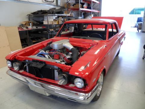 1973 Ford Ranchero - A red custom coupe is shown in a workshop with its hood and trunk open, revealing the engine.