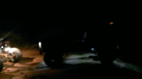 1994 Ford Bronco - A dark 1992 Ford Bronco is visible in a nighttime scene, with another vehicle partially seen to its left.