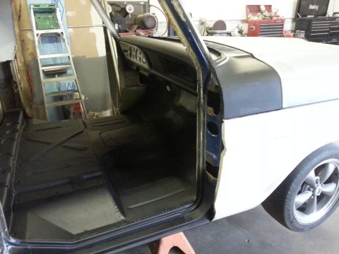 1967 Ford F-100 - The interior of a 1967 Ford F-100 is visible with the driver's door open, revealing the floor and dashboard.