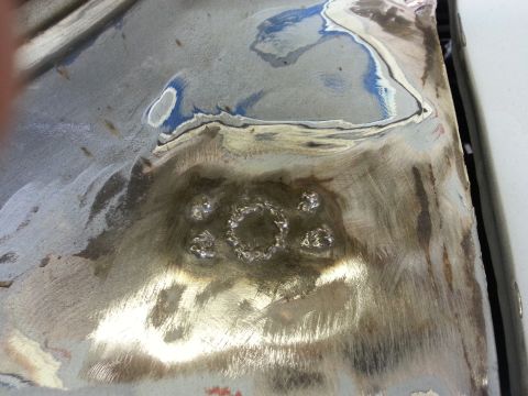 1967 Ford F-100 - Close-up of a metal panel showing evidence of repair work, including welding and primer.