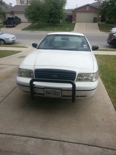1999 Ford Crown Victoria - A white 2000 Ford Crown Victoria is parked on a concrete driveway in front of a suburban house.