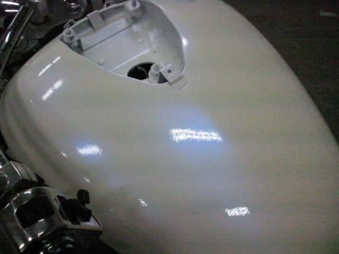 1995 Ford F-150 - Close-up of a motorcycle's white fuel tank and chrome handlebars.