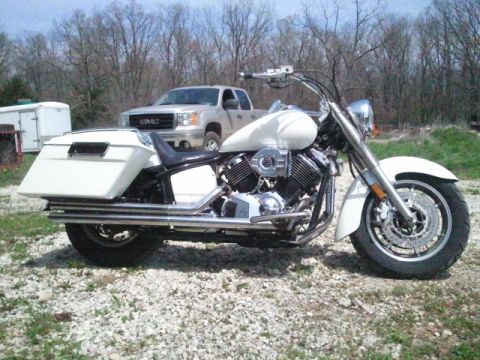 1995 Ford F-150 - A white motorcycle with saddlebags is parked on a gravel lot with a GMC pickup truck behind it.