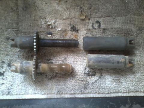 1970 Ford Bronco - Two brake adjusters and two brake drums are laid out on a textured cloth surface.