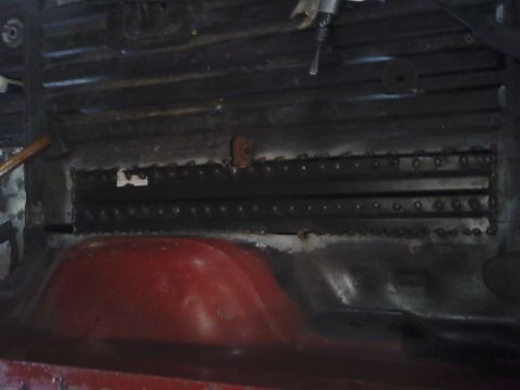 1978 Ford Bronco - Close-up view of the interior floor pan, showing repair work and a red wheel well.