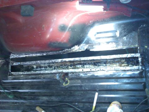 1978 Ford Bronco - Close-up of heavily rusted metal frame and undercarriage components, likely requiring repair.